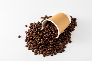 Coffee Beans Spilled from Brown Paper Cup on White Background