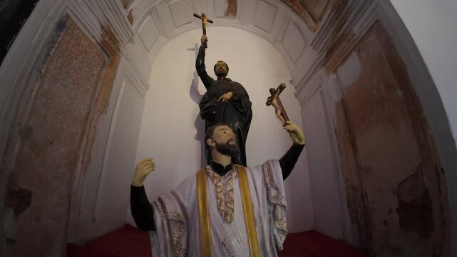 An ornate religious statue of St. Francis Xavier housed within the magnificent golden altar of the Basilica of Bom Jesus, a UNESCO World Heritage site in Old Goa, India