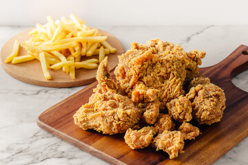 Crispy Fried Chicken with French Fries on Wooden Cutting Board