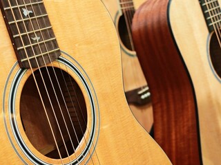 Obraz premium The acoustic guitar's warm wood grain exhibits a swirling pattern across its smooth, matte surface, suggesting a handcrafted quality and inviting a sense of musical intimacy.