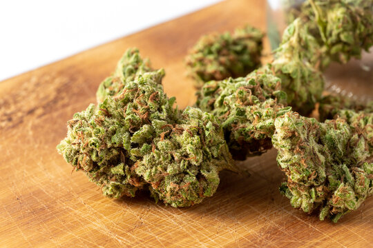 Close-Up of Green Flowering Cannabis Buds on Wooden Surface