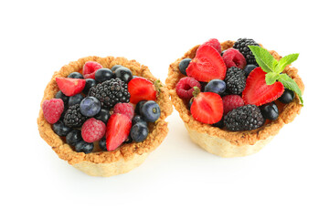 Sweet tartlets with different fresh berries and mint on white background