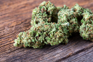 Close-up View of Fresh Green Cannabis Buds on Natural Wooden Surface