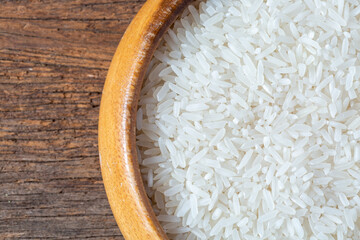 Close-Up of Raw White Rice in Wooden Bowl on Rustic Wooden Table