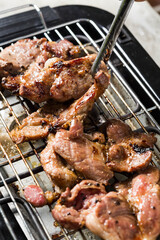 Grilled Meat on Barbecue with Tongs Cooking in Kitchen Setting