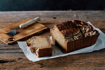 Sliced Banana Bread with Almonds on Wooden Table Surrounded by Cutlery