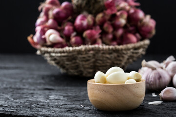 Fresh Garlic Cloves in Wooden Bowl with Shallots in Background