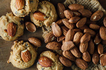 Freshly Baked Cookies with Almonds and Raw Almonds on Wooden Table