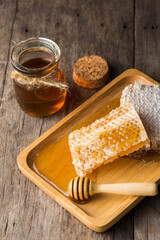Honeycomb and Jar of Honey on Wooden Table with Natural Light
