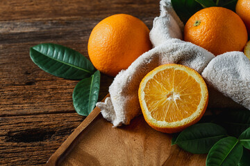 Fresh Oranges Displayed on Wooden Board with Green Leaves