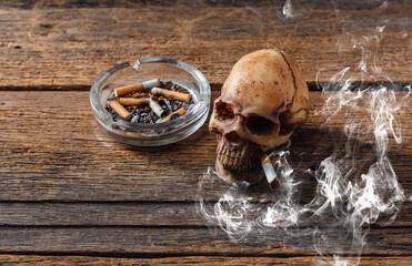 Skull with Cigarette and Ashtray on Rustic Wooden Table Background