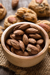 Fresh Almonds in Wooden Bowl with Cookies on Rustic Table