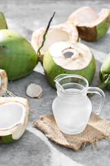 Fresh Coconut Water in Glass Jug with Open Coconut Shells