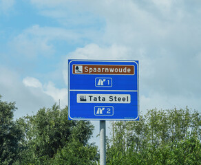 A highway sign in the Netherlands showing directions to Spaarnwoude recreation area and Tata Steel industry.