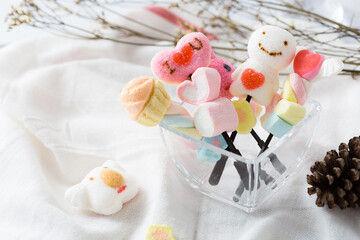 Colorful Decorative Marshmallows in a Glass Bowl on White Fabric