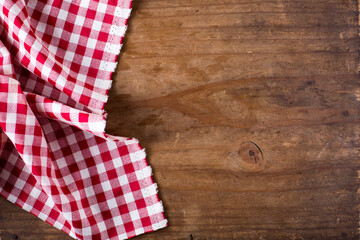 Obraz premium Red and White Checkered Tablecloth on Rustic Wooden Surface