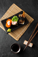 Delicious Variety of Sushi Served on a Black Plate with Chopsticks