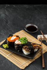 Fresh Sushi Rolls with Toppings on a Stylish Black Plate