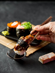 Delicious Sushi Dish with Soy Sauce and Chopsticks on Dark Background
