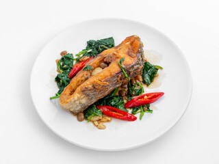 Delicious grilled fish with spinach and red chili peppers on plate