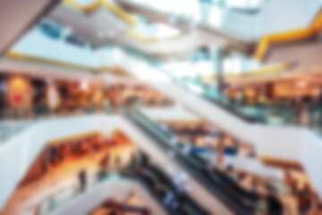 A blurred image of an abstract background featuring escalators and people in a shopping mall, reminiscent of Shenzhen, China.