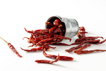Dried Red Chili Peppers Spilling from Small Metal Bucket on White Background