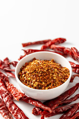 Ground Red Chili Powder with Dried Red Chili Peppers on White Background