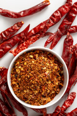 Spicy Red Chili Powder in Bowl Surrounded by Dried Chili Peppers