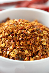 Close-Up View of Spicy Chili Flakes in White Bowl on Table
