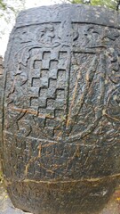  Historic gravestone with intricate carvings and engravings displayed in the open area of the Chapel of St. Catherine, Old Goa