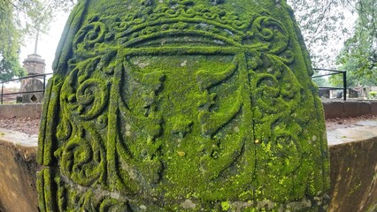  Historic gravestone with intricate carvings and engravings displayed in the open area of the Chapel of St. Catherine, Old Goa