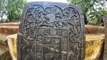  Historic gravestone with intricate carvings and engravings displayed in the open area of the Chapel of St. Catherine, Old Goa