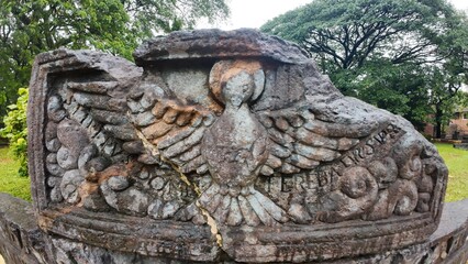  Historic gravestone with intricate carvings and engravings displayed in the open area of the Chapel of St. Catherine, Old Goa