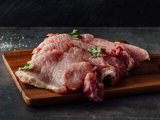 Fototapeta premium Fresh Raw Pork Meat on Wooden Cutting Board with Herbs