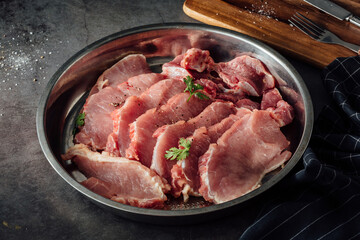 Fresh Raw Pork Chops on Metal Plate with Seasoning and Herbs