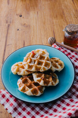 Delicious Waffles Served on Blue Plate with Honey and Red Checkered Cloth