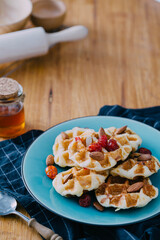 Delicious Golden Waffles with Fresh Berries and Nuts on a Plate