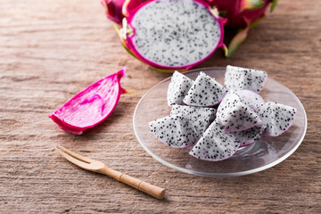 Fresh Dragon Fruit Slices on Plate with Wooden Fork and Background