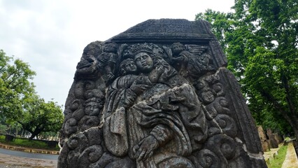 Historic gravestone with intricate carvings and engravings displayed in the open area of the Chapel of St. Catherine, Old Goa