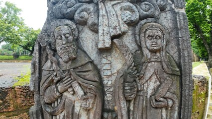  Historic gravestone with intricate carvings and engravings displayed in the open area of the Chapel of St. Catherine, Old Goa