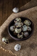 Quail Eggs in Wooden Bowl on Rustic Table with Linen Cloth