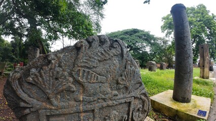  Historic gravestone with intricate carvings and engravings displayed in the open area of the Chapel of St. Catherine, Old Goa