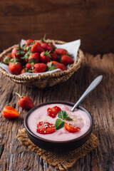 Fresh Strawberry Yogurt in Bowl with Strawberries on Wooden Table