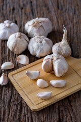 Fresh Garlic Bulbs and Cloves on Wooden Cutting Board Background