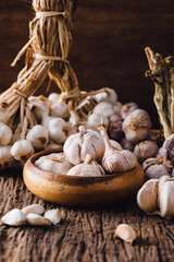 Fresh Garlic Bulbs and Cloves in Rustic Wooden Bowl and Farm Background