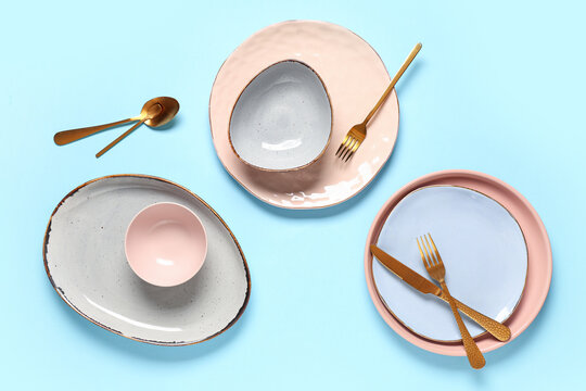 Beautiful table setting with golden cutlery on blue background - Powered by Adobe