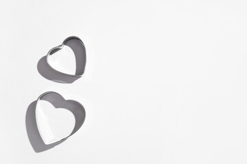 Cookie cutters in shape of heart on grey background