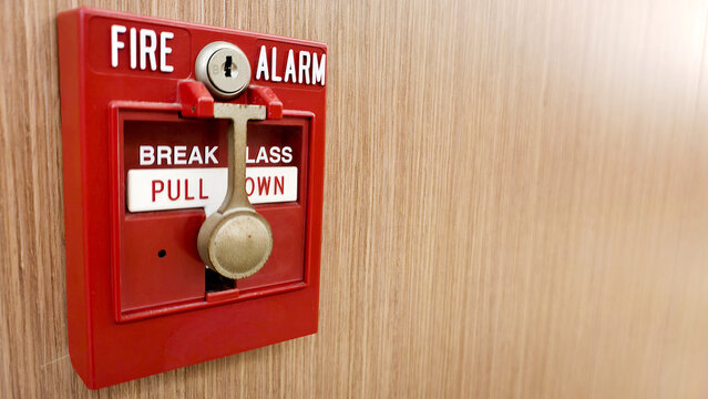 Fire alarm box with pull down handle on wooden wall, emergency safety device for alerting fire danger