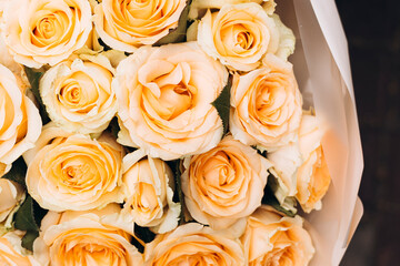 Close-up peach bouquet on background of orange roses floral texture.
