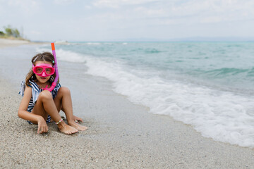 Child enjoying a beach day with snorkeling gear at a serene coastline